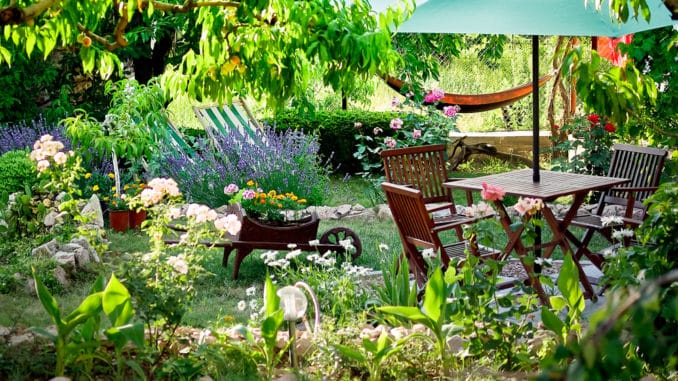 Wunderschöner Garten mit Holztisch und Stühlen